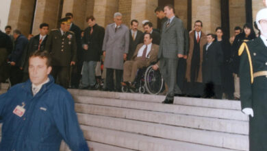 Görselde Ahmet Faruk Öztimur ile birlikte beraberinde yürüyen kişiler yüksek bir merdivenden aşağı inmeye çalışıyor. Öztimur tekerlekli sandalye üzerinde oturuyor.