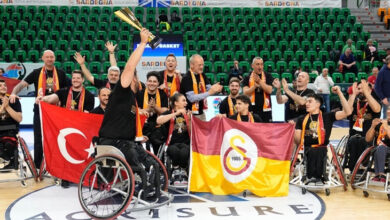 Galatasaray Fuzul Tekerlekli Sandalye Erkek Basketbol Takımı sporcuları kazandıkları kupayı havaya kaldırarak sevinç gösterisi yapıyorlar.