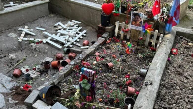 Görselde bir çocuk mezarı görülüyor. Mezar renkli çiçekler, oyuncaklar, Türk ve Azerbaycan bayrakları, bir fotoğraf, rüzgar gülü ve kalp figürüyle süslenmiş. Ancak çevrede birçok çiçek saksısı devrilmiş, haç sembolleri kırılmış ve yere saçılmış. Bu durum mezarın tahrip edildiğini gösteriyor.