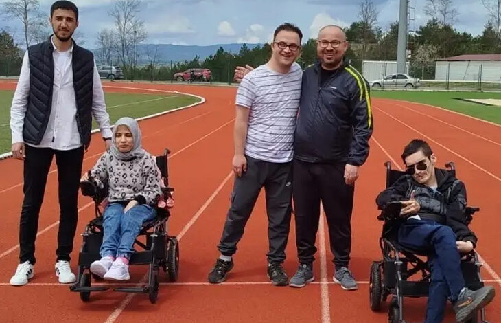 Bu fotoğraf, Kastamonu Üniversitesi'nde gerçekleştirilen anlamlı bir sosyal etkileşim projesine ait. Bir spor pistinde çekilmiş karede, tekerlekli sandalyedeki bireylerle birlikte gönüllü öğrenciler yer alıyor. Hep birlikte gülümseyerek verdikleri poz, kampüs ortamında engelli bireylerle kurulan sıcak dostluğu ve dayanışmayı yansıtıyor.
