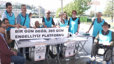 365 Gün Engelliyiz Platformu üyeleri imza kampanyası standında pankart açarak poz veriyor.
