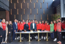 Türkiye Özel Sporcular Spor Federasyonu Yönetim Kurulu Üyesi ve iş insanı Sayın Nuray Yılmaz, Başkan Birol Aydın, üyeler ile Özel Sporcular Para Atletizm Milli Takımı, pastaların olduğu etkinlik masası başında poz veriyor.