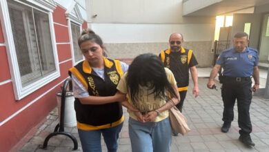 Kadın polis gözaltına alınan öğretmeni götürüyor.