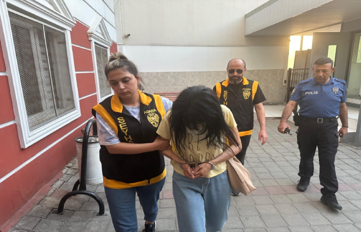 Kadın polis gözaltına alınan öğretmeni götürüyor.