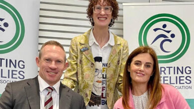 Görselde, Ali France ayakta ve iki kişinin ortasında duruyor. Sağında ve solunda ise kendisine destek veren bir kadın ve erkek var.