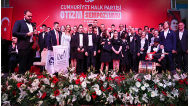 Bu fotoğraf, Cumhuriyet Halk Partisi (CHP) tarafından düzenlenen bir Otizm Sempozyumu etkinliğine ait. Görselde birçok katılımcı, sahnede toplu halde poz verirken görülüyor.