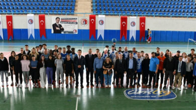 Bu görselde, Çanakkale Onsekiz Mart Üniversitesi (ÇOMÜ) tarafından Hasan Mevsuf Spor Salonu’nda düzenlenen bir Goalball (görme engellilere özel bir spor) etkinliği sonrası çekilmiş toplu fotoğraf yer almaktadır. Fotoğrafta; sporcular, üniversite yöneticileri, antrenörler ve etkinlik katılımcıları birlikte poz vermektedir.