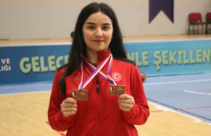 Halenur Küçüksevgili boynunda bulunan madalyaları tutarak poz veriyor.
