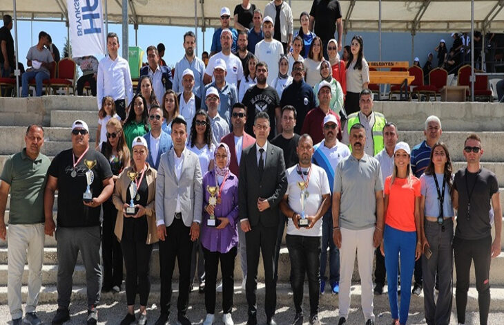 Bu görselde, Hatay Büyükşehir Belediyesi’nin Engelliler Haftası kapsamında düzenlediği bir etkinlikte bir araya gelen kalabalık bir grup yer alıyor. Katılımcılar açık alanda, tribün önünde toplu halde poz veriyor. Ön sırada bazı kişilerin ellerinde ödül kupaları ve madalyalar var; bu da etkinlik kapsamında yarışmalar ya da ödüllü faaliyetler düzenlendiğini gösteriyor. Farklı yaş ve cinsiyetlerden bireylerin bir arada olması, kapsayıcılığı ve toplumsal dayanışmayı vurguluyor.