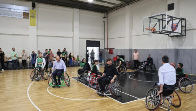 Konya Büyükşehir Belediye Başkanı Uğur İbrahim Altay, bir basketbol sahasında engelli tekerlekli sandalye kullanacaklar basketbolcular ile birlikte basketbol oynuyor.