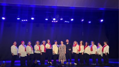 Fotoğrafta, bir sahnede büyük çoğunluğu kadınlardan oluşan bir grup yan yana durarak fotoğraf çekimine katılıyorlar.