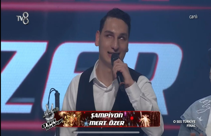 Mert Özer şampiyon olduktan sonra mikrofonla konuşma yapıyor.