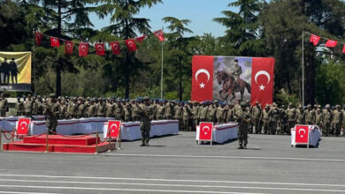 Fotoğraf, engelli bireylerin temsili askerlik törenini sırasında çekilmiş. Engelli bireyler ve askerler tören alanında askeri nizama uygun şekilde selam veriyorlar.