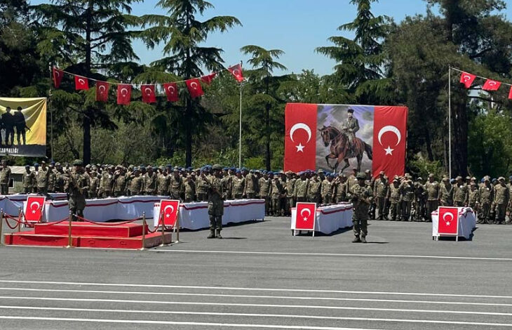 Fotoğraf, engelli bireylerin temsili askerlik törenini sırasında çekilmiş. Engelli bireyler ve askerler tören alanında askeri nizama uygun şekilde selam veriyorlar.
