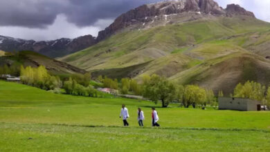 Dağ yamaçlarında üç sağlık ekibi personeli arka arkaya yürüyor.