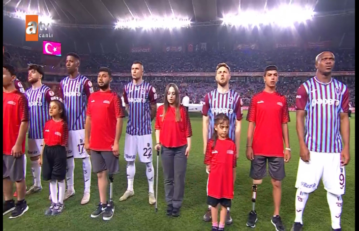 Trabzonsporlu futbolcuların yanında bulunan engelliler seremonide bulunuyor.