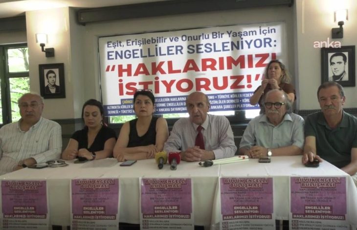 Görselde engelli hakları için düzenlenen bir basın toplantısı görülüyor. Altı kişi, “Haklarımızı istiyoruz!” yazılı pankart önünde oturuyor. Masada mikrofonlar ve “Büyük Engelli Buluşması” afişleri yer alıyor. Toplantıda 14 Haziran’da Ankara’da yapılacak mitinge çağrı yapılıyor.