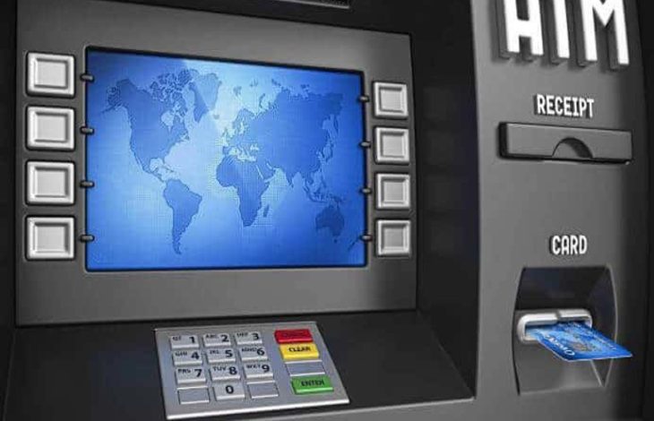 Görselde bir ATM cihazı yer alıyor. Ekranında mavi tonlarda bir dünya haritası görüntülenmiş. Ekranın her iki yanında işlem tuşları bulunuyor. Alt kısımda ise rakam tuş takımı, renkli işlem tuşları (iptal, düzelt, giriş) yer almakta. Sağ tarafta kart giriş yuvasında mavi renkli bir banka kartı takılı duruyor. Ayrıca "RECEIPT" (fiş) ve "CARD" (kart) bölümleri de etiketlenmiş şekilde görülüyor. Görsel, muhtemelen erişilebilirlik özelliklerine sahip yeni nesil ATM'leri temsil ediyor.