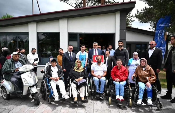 Erzurum Valisi Mustafa Çiftçi ile engelliler, Türkiye Sakatlar Derneği hizmet binası önünde hatıra fotoğrafı çektiriyor.