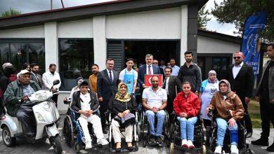 Görselde, Erzurum Valisi Mustafa Çiftçi'nin de aralarında bulunduğu bir grup insan, bir bina önünde toplanmış. Ön sırada tekerlekli sandalye kullanan engelli bireyler oturuyor; arkada ise etkinliğe katılan protokol üyeleri ve diğer katılımcılar yer alıyor. Sağ köşede “Erzurum Büyükşehir Belediyesi” logolu bir bayrak dikkat çekiyor. Etkinlik, Türkiye Sakatlar Derneği Erzurum Şubesi tarafından düzenlenen “Arzuhal Günleri” kapsamında gerçekleşmiş.