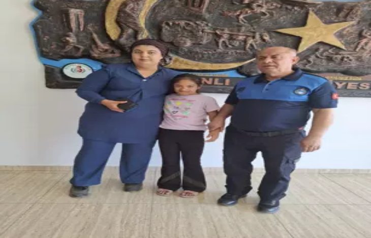 Fotoğrafta, down sendromlu bir çocuk ile annesi birbirine sarılmış, yanlarında ise bir zabıta memuru yer alıyor.