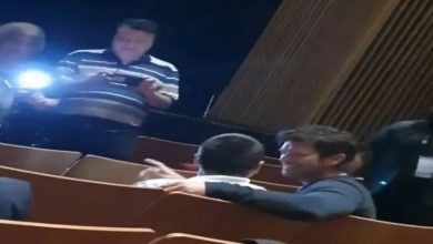 Görselde bir tiyatro salonunda çekilmiş bir an yer alıyor. Önde, oyuncu Kıvanç Tatlıtuğ olduğu anlaşılan kişi, bir engelli bireyle samimi bir şekilde sohbet ediyor; kolunu onun omzuna atmış. Arka planda başka izleyiciler bulunuyor, bir kişi cep telefonuyla görüntü alıyor ve yanındaki kişi flaşla aydınlatıyor. Ortam loş ama sıcak bir etkileşim hissediliyor.