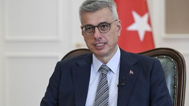 "Fotoğrafta Sağlık Bakanı Kemal Memişoğlu yer alıyor. Bakanın arkasında ise Türk bayrağı ile Sağlık Bakanlığı'nın logosunu taşıyan bir bayrak görülüyor."