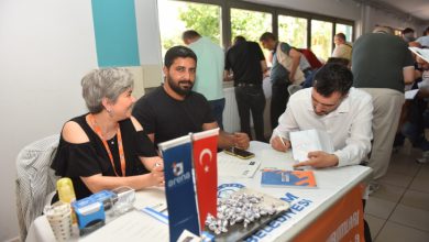 Bir kadın ve bir erkek İnsan Kaynakları personeli yanında iş formu dolduran engelli erkek aday.