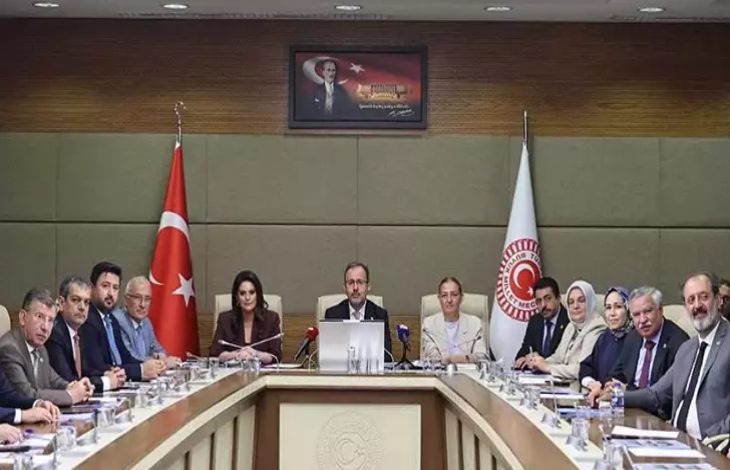 Bu fotoğraf, Türkiye Büyük Millet Meclisi'nde (TBMM) gerçekleşen resmi bir komisyon toplantısını gösteriyor. Masanın başında yer alan kişi, AK Parti İzmir Milletvekili Mehmet Muharrem Kasapoğlu. Arka planda Türk bayrağı, TBMM bayrağı ve Atatürk portresi yer alıyor. Katılımcılar resmi giyimli, çoğunluğu milletvekili ya da bürokratlardan oluşuyor. Masada belgeler, mikrofonlar, isimlikler ve su bardakları bulunuyor. Genel atmosfer ciddi, resmi ve kurumsal.