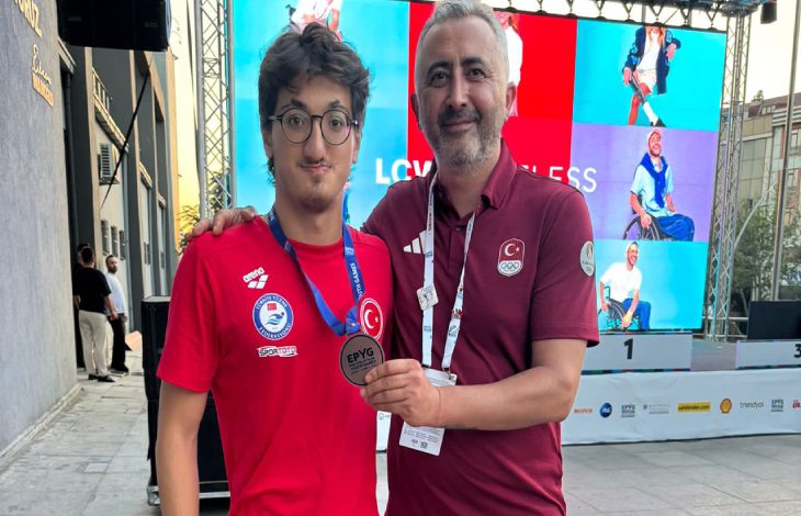 Para Yüzme Milli Takım antrenörü Çetin Koçak, Paralimpik Milli Yüzücü Turgut Aslan Yaraman'ın boynundaki madalyayı tutarak poz veriyorlar