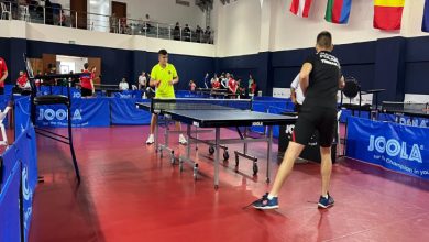 Masa tenisi kortunda rakip iki erkek maç yapıyor.