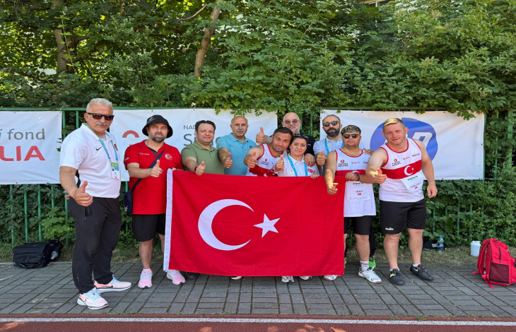 Down Sendrom Atletizm Milli Takımının erkek sporcuları teknik kafile ile Türk Bayrağını tutarak poz veriyor.