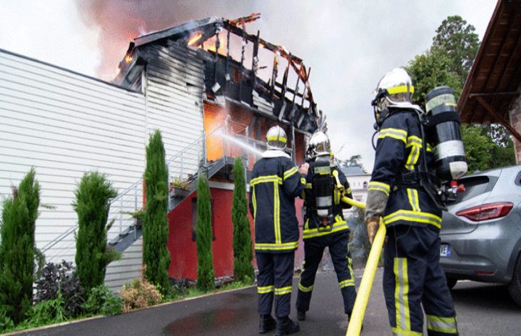 Üç itfaiyeci sokakta bulunarak, yanan müstakil yapıya müdahale ediyor.
