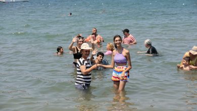 Görselde engelli bireyler ve aileleri denizin içerisinde yüzerken görünüyor. Engelli bireylerin genç ve çocuklardan oluşan karma bir grup olduğu görülüyor.