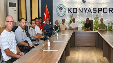 Görselde, Konyaspor logosunun yer aldığı bir toplantı salonunda çekilmiş bir kare yer alıyor. Masanın etrafında çoğu tekerlekli sandalyede oturan yaklaşık 13 kişi bulunuyor. Sol tarafta Türk bayrağı görülüyor. Duvarın arka kısmında "KONYASPOR" yazısı büyük harflerle yer almakta. Katılımcılar ciddi ve dikkatli bir şekilde kameraya poz veriyor.