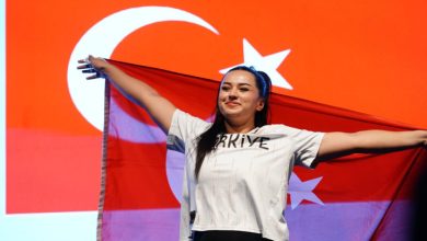 Ebrar Keskin sırtına aldığı Türk Bayrağını sevinçle tutuyor.