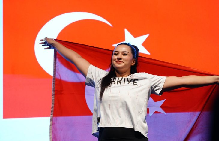 Ebrar Keskin sırtına aldığı Türk Bayrağını sevinçle tutuyor.