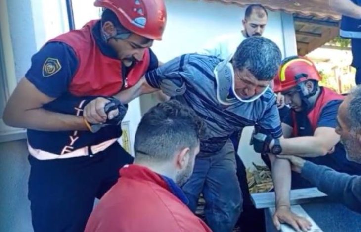 Görselde, işitme engelli bir adam (boynunda boyunluk takılı) yaklaşık 5 metrelik bir kuyudan itfaiye ekipleri tarafından kurtarılıyor. İtfaiye personelleri koruyucu kask ve üniformalar içinde, adamı dikkatlice yukarı çıkarırken ona destek oluyorlar. Kurtarılan kişi oldukça yorgun ve üzgün görünüyor, çevresindeki ekip ise ciddi ve yardım odaklı bir şekilde müdahalede bulunuyor. Yardımlaşma ve dayanışma duygusu ön planda.