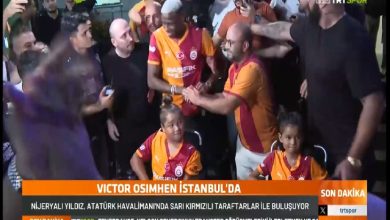 Görselde, Galatasaray’ın yeni transferi Nijeryalı futbolcu Victor Osimhen, Atatürk Havalimanı’nda sarı-kırmızılı taraftarlar tarafından coşkuyla karşılanıyor. Osimhen Galatasaray formasıyla ortada yer alırken, etrafı taraftarlarla çevrili. Kalabalığın içinde dikkat çeken detaylardan biri de, Galatasaray forması giymiş iki engelli kız çocuğunun tekerlekli sandalyede ön sırada yer alması.