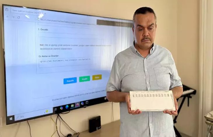 Görselde, görme engelli uzman özel eğitim öğretmeni Mahir Saygı, konuşma güçlüğü çeken bireyler için geliştirdiği yerli alternatif iletişim cihazı gösteriyor.