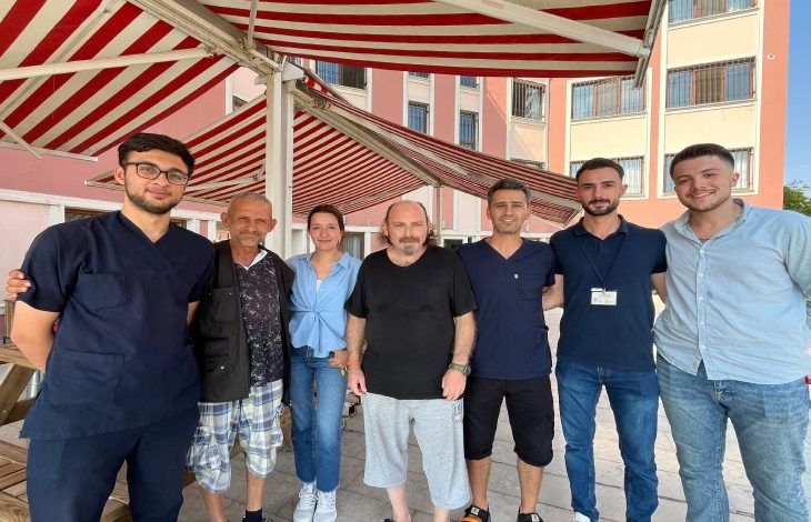 Bakımevi personelleri ile hizmet alan engelli bireyler yan yana ayakta durarak poz veriyorlar.
