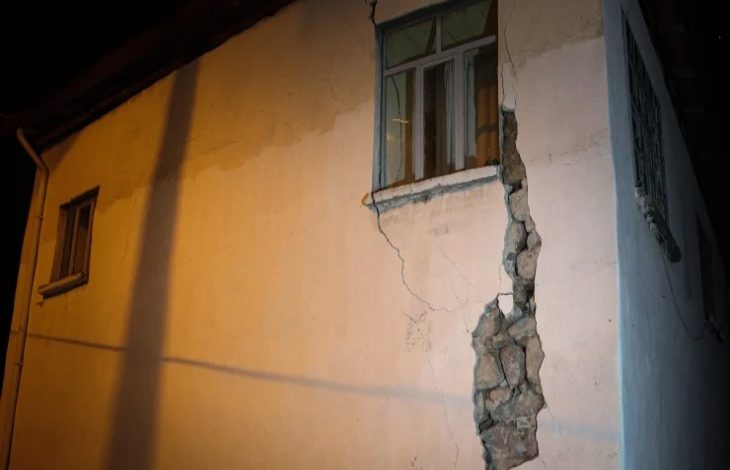 Görselde, Belıkesir depremi sonrası gece çekilmiş bir binanın köşesinde büyük bir çatlak ve duvarın dökülmüş kısmı görülüyor. Pencerelerden biri aydınlık, duvarın alt kısmında ise taş örgü yapısı ortaya çıkmış.