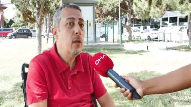Görselde, tetraplejili engelli birey Gökhan Ayık, kırmızı renkli üzerinde “DHA” yazılı mikrofona doğru konuşuyor.