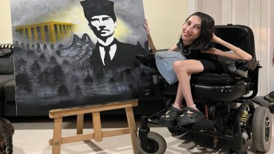 Tekerlekli sandalyesinde poz veren Gülçin Sipahi’nin yanında bulunan paletteki eserinde Atatürk, Anıtkabir, kurt figürü ve sisler arasındaki orman detayları yer alıyor.
