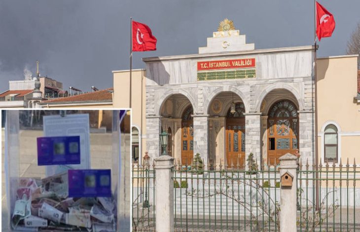 Görselde, eski bir binanın üzerinde İstanbul Valiliği yazısı ve iki tane Türk bayrağı önünde yer alıyor. Fotoğrafın sol alt köşesinde kaldırılmış bir bağış standı yer alıyor.