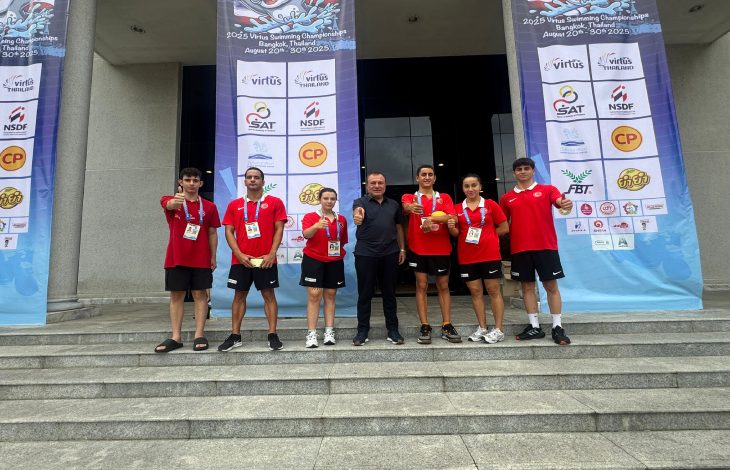 Türkiye Özel Sporcular Spor Federasyonu Başkanı Birol Aydın, spor salonu önünde milli sporcularla birlikte poz veriyor.