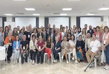 Görselde, bir konferans salonunda düzenlenen toplu bir etkinlikte, farklı yaş ve cinsiyetten yaklaşık 60 kişilik bir grup kameraya poz veriyor. Ön sırada oturanlar, arka sırada ise ayakta duran katılımcılar bulunuyor. Katılımcıların boyunlarında yaka kartları takılı; bu, etkinliğin resmi bir çalıştay veya zirve olduğunu gösteriyor. Fotoğraf, “Bağımsız Yaşam ve Eşitlik” temalı bir çalıştaya katılanların birlikte verdiği güçlü bir birliktelik pozunu yansıtıyor.