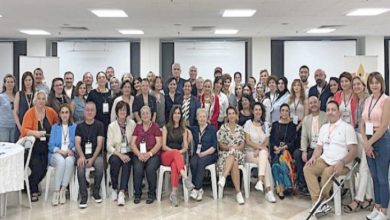 Görselde, bir konferans salonunda düzenlenen toplu bir etkinlikte, farklı yaş ve cinsiyetten yaklaşık 60 kişilik bir grup kameraya poz veriyor. Ön sırada oturanlar, arka sırada ise ayakta duran katılımcılar bulunuyor. Katılımcıların boyunlarında yaka kartları takılı; bu, etkinliğin resmi bir çalıştay veya zirve olduğunu gösteriyor. Fotoğraf, “Bağımsız Yaşam ve Eşitlik” temalı bir çalıştaya katılanların birlikte verdiği güçlü bir birliktelik pozunu yansıtıyor.