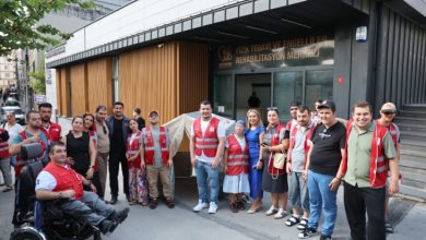 Fizik Tedavi ve Rehabilitasyon Merkezi önünde Kızılay personeli, engelliler ve aileleri hatıra pozu veriyor.