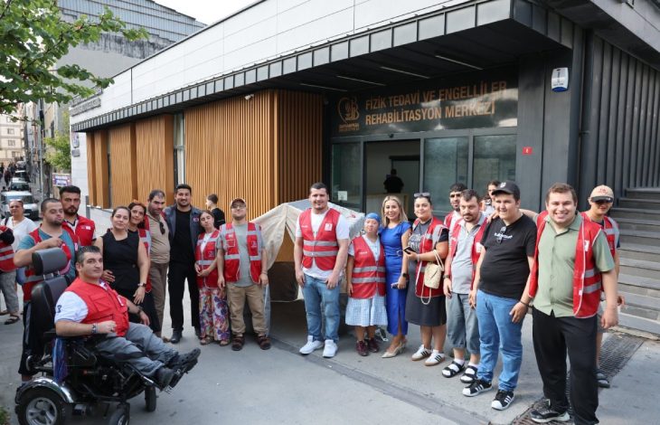 Fizik Tedavi ve Rehabilitasyon Merkezi önünde Kızılay personeli, engelliler ve aileleri hatıra pozu veriyor.